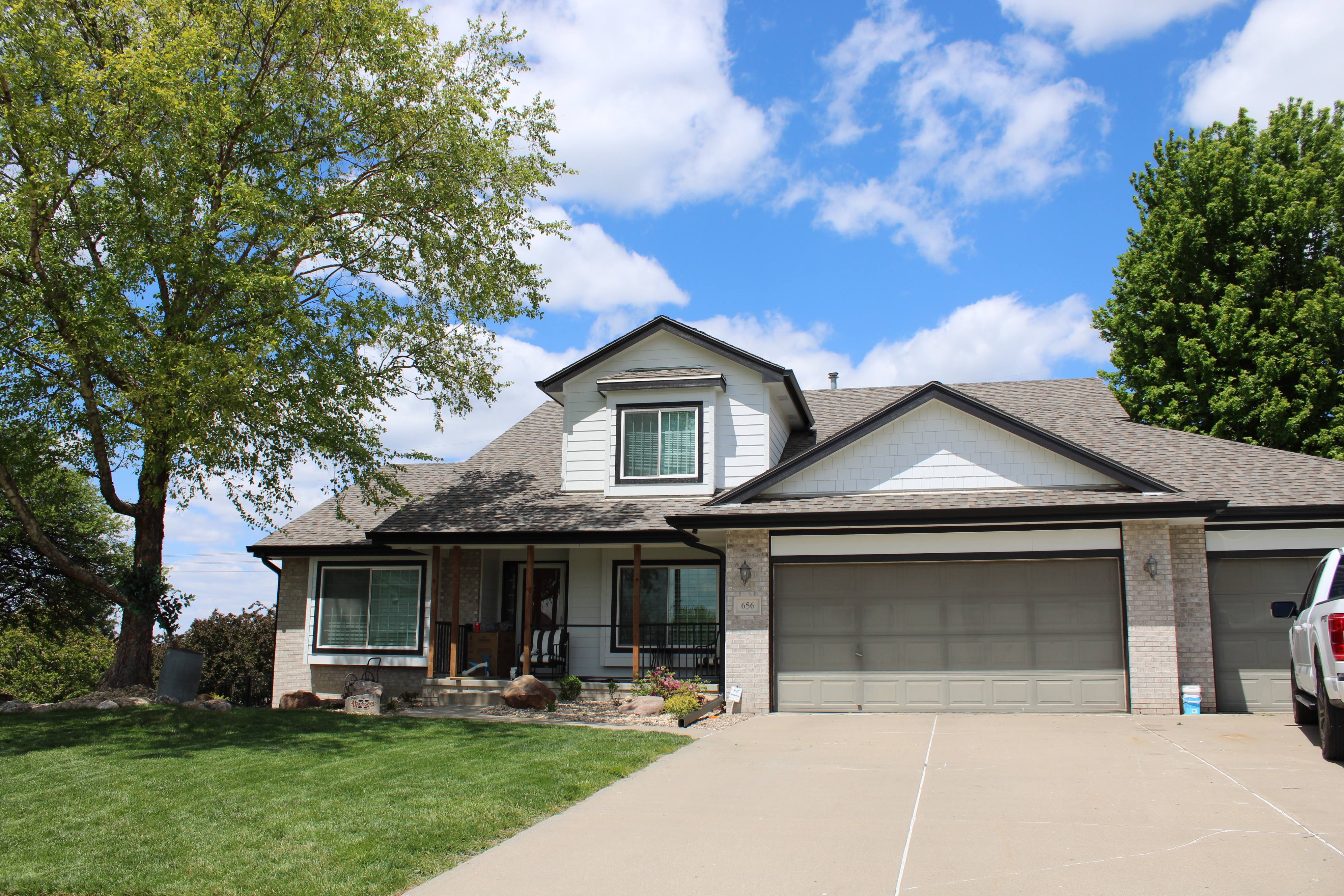 Omaha home with new dark seamless gutters along the roofline and front porch